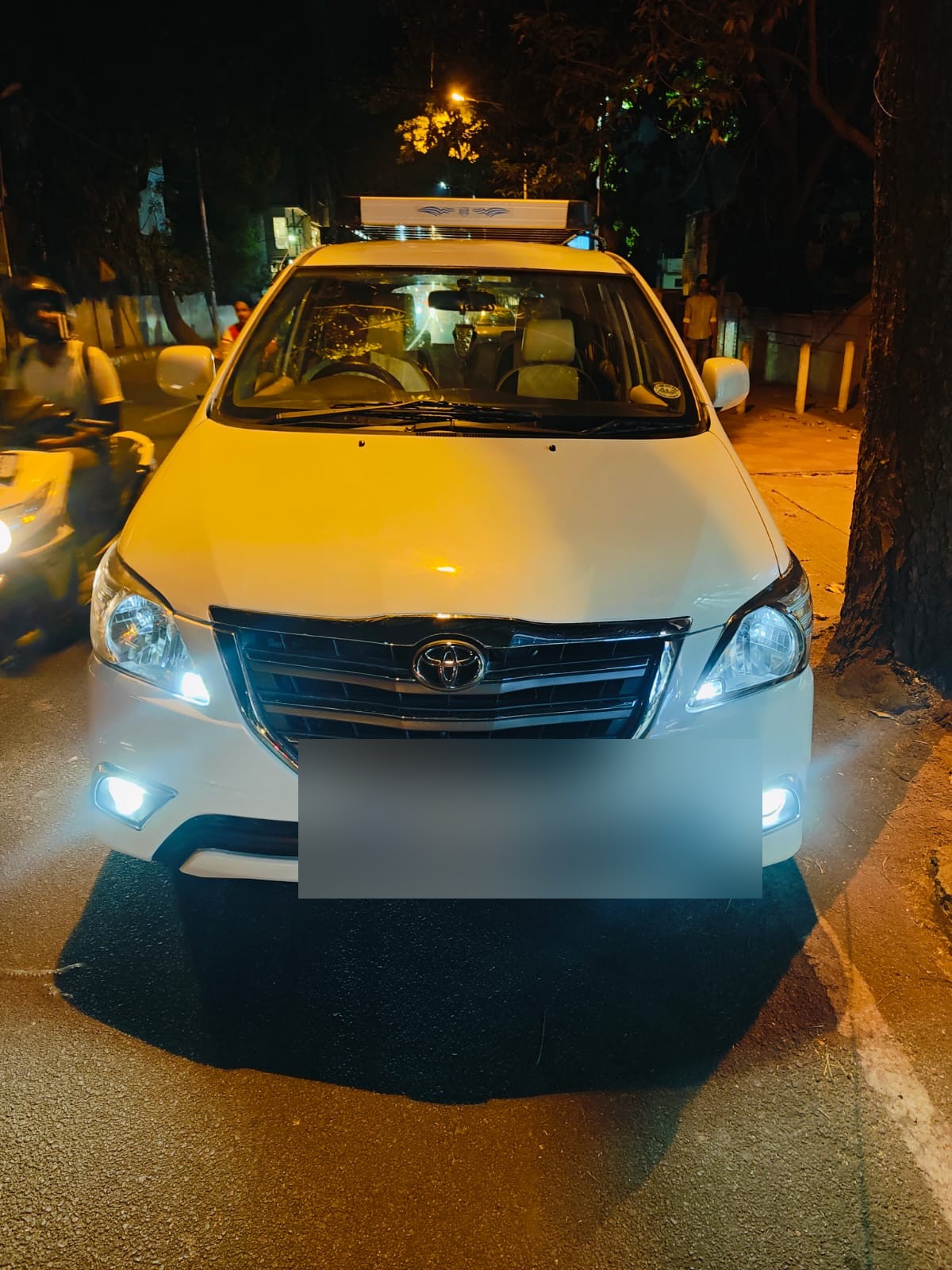 Toyota Innova at night with headlights on
